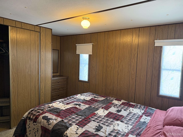 bedroom featuring heating unit and wood walls