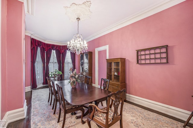 dining space featuring hardwood / wood-style flooring, ornamental molding, and a notable chandelier