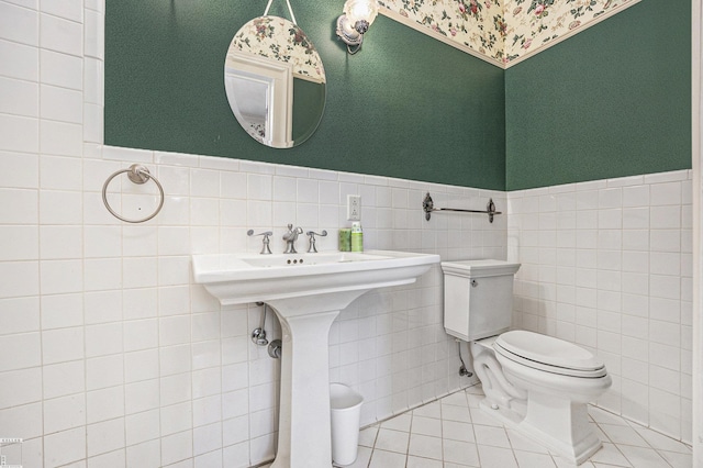 bathroom with tile patterned flooring, tile walls, and toilet