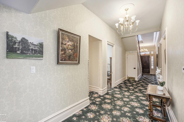 hall featuring dark colored carpet, vaulted ceiling, and a notable chandelier