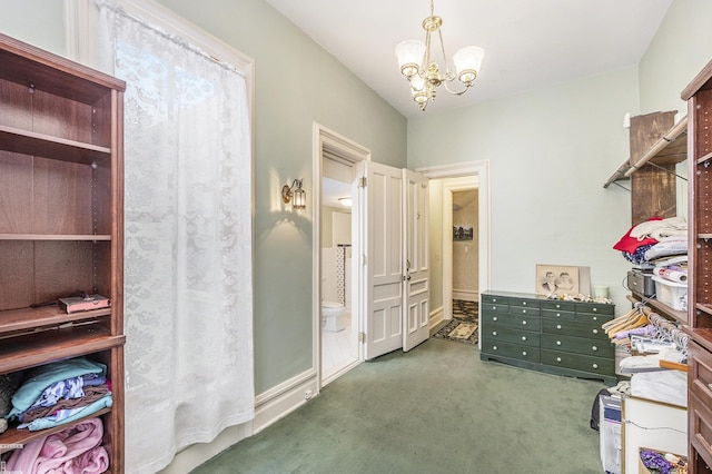 walk in closet with a notable chandelier and dark colored carpet