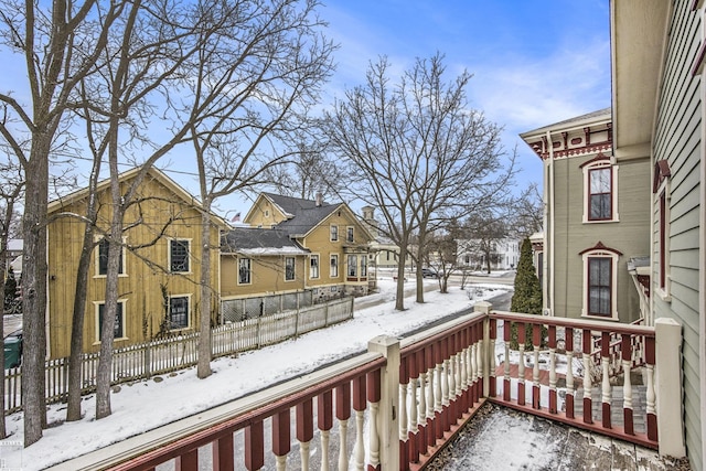 view of snow covered back of property