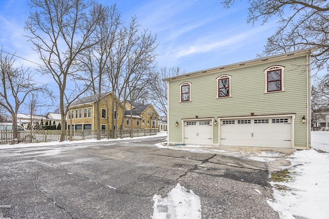 snow covered property featuring a garage