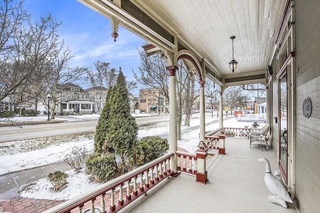 snow covered patio featuring a porch