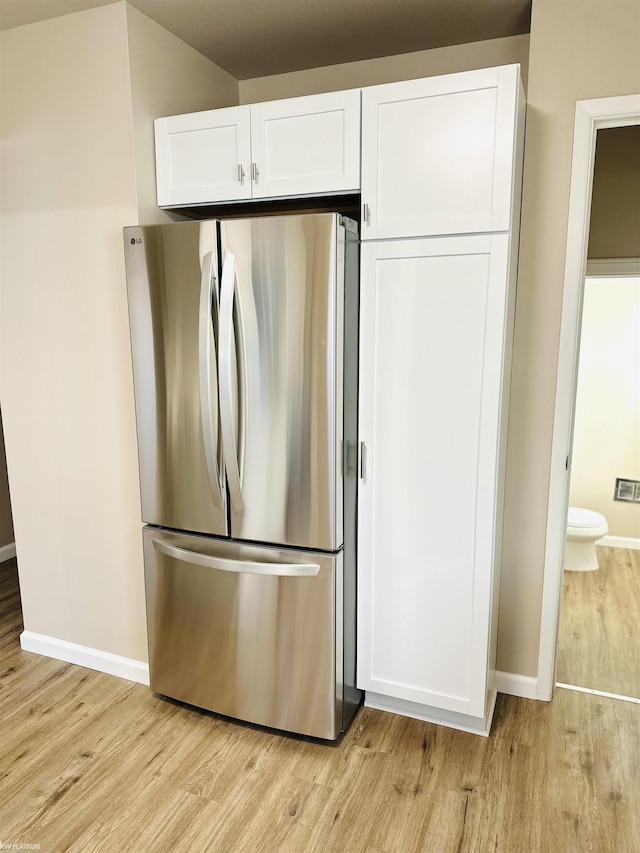 kitchen featuring white cabinetry, stainless steel refrigerator, and light hardwood / wood-style flooring