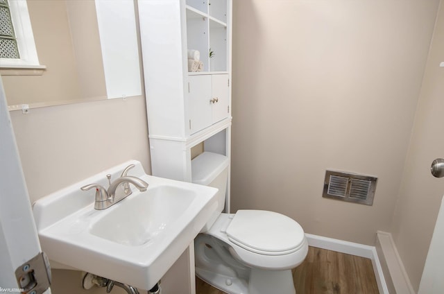 bathroom featuring sink, wood-type flooring, and toilet