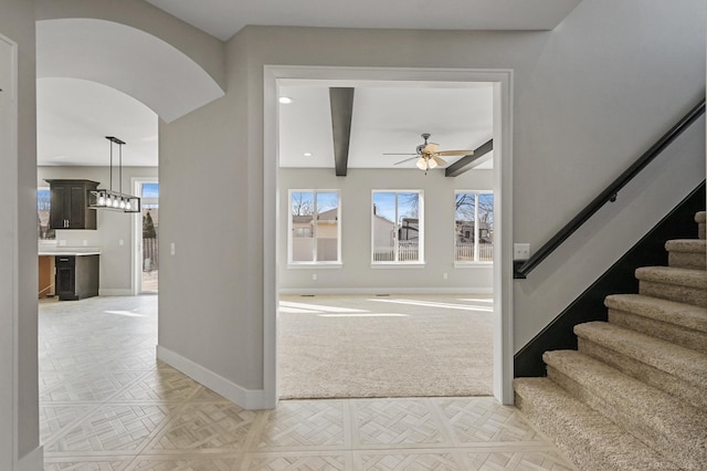 foyer entrance featuring beam ceiling, parquet flooring, and ceiling fan