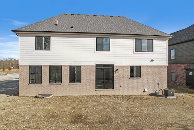 rear view of property featuring a yard and central AC unit