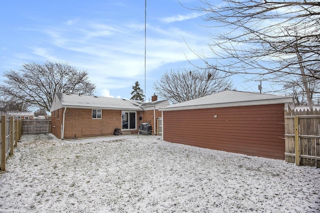 view of snow covered rear of property