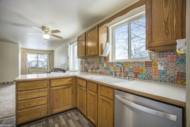 kitchen featuring dishwasher, sink, backsplash, ceiling fan, and kitchen peninsula