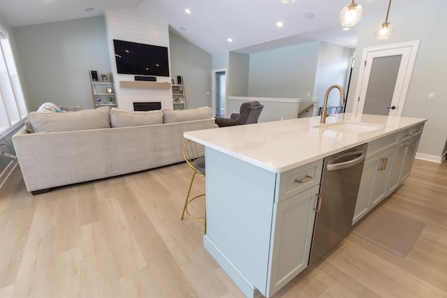 kitchen featuring a kitchen island with sink, sink, decorative light fixtures, and dishwasher