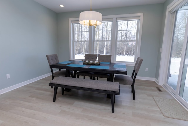 dining space with an inviting chandelier and light hardwood / wood-style floors