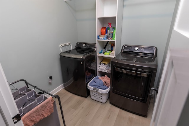 laundry room with independent washer and dryer and light hardwood / wood-style flooring