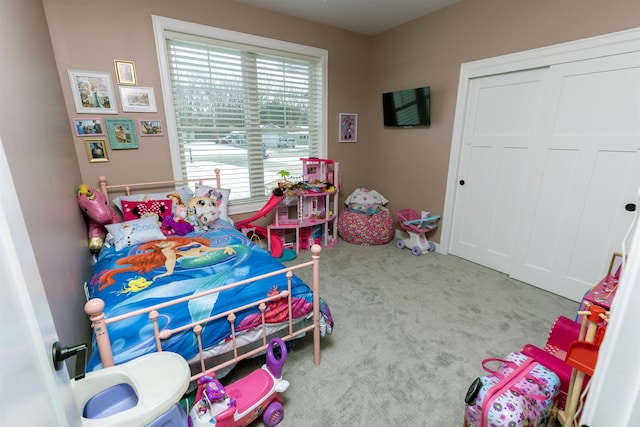 bedroom featuring light colored carpet and a closet