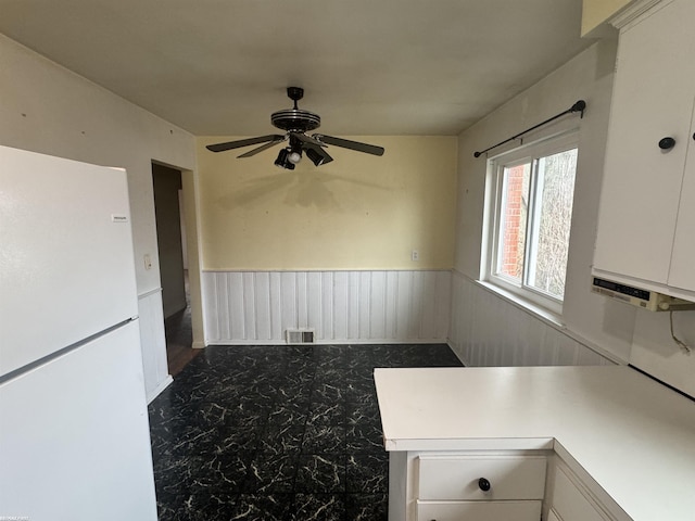 kitchen featuring white cabinetry, ceiling fan, and white refrigerator