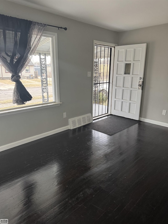 spare room with a healthy amount of sunlight and hardwood / wood-style floors