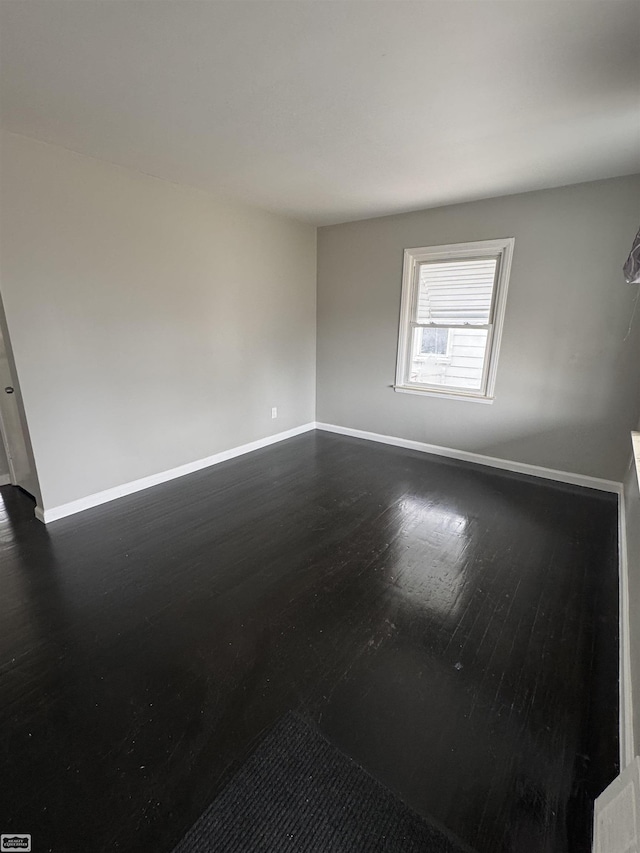 spare room with dark hardwood / wood-style flooring