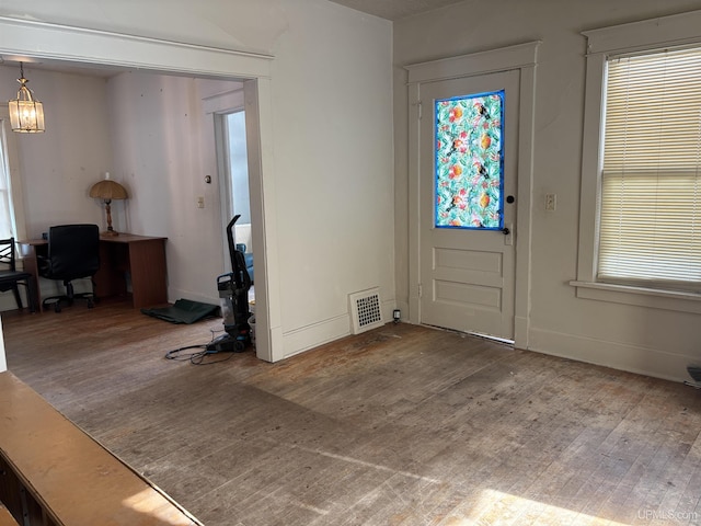 entryway with hardwood / wood-style flooring and a notable chandelier