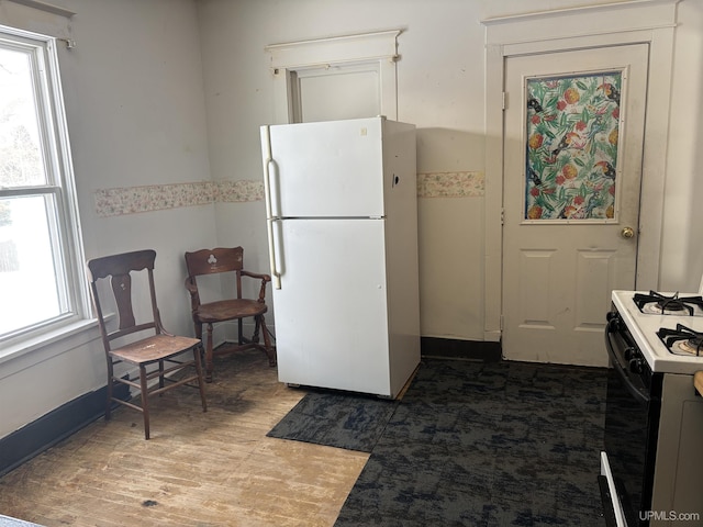 kitchen with white refrigerator, dark hardwood / wood-style floors, and gas stove