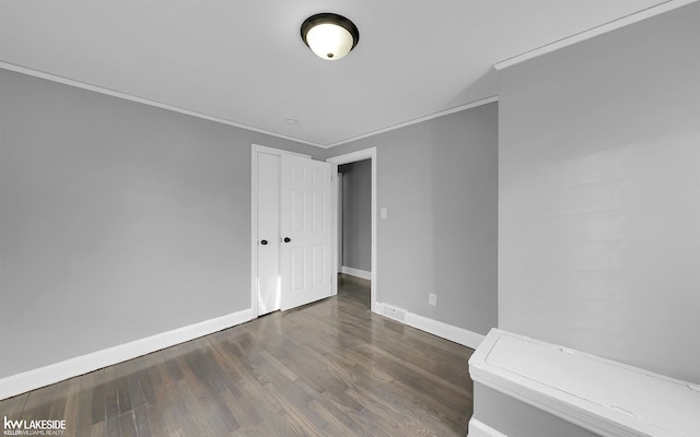 empty room featuring ornamental molding and dark hardwood / wood-style floors