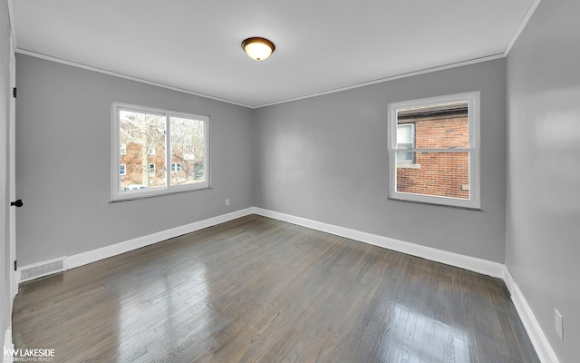 empty room with dark hardwood / wood-style flooring and ornamental molding