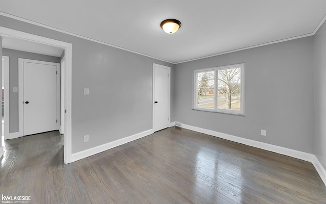 unfurnished room featuring ornamental molding and dark hardwood / wood-style flooring