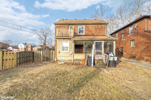 rear view of property with a sunroom and a lawn