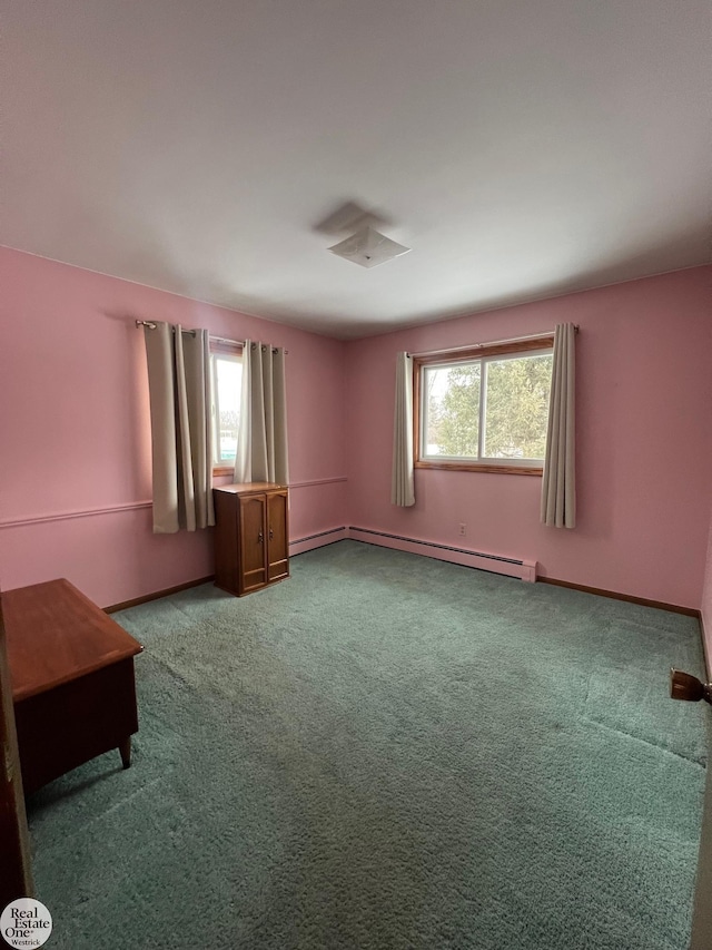 carpeted spare room with a baseboard heating unit