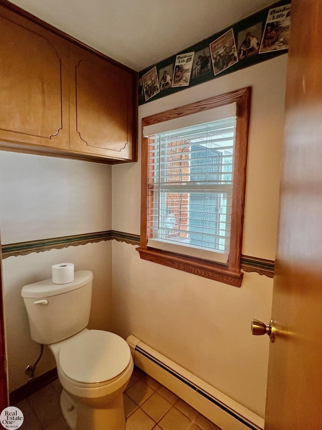 bathroom featuring a baseboard heating unit and toilet