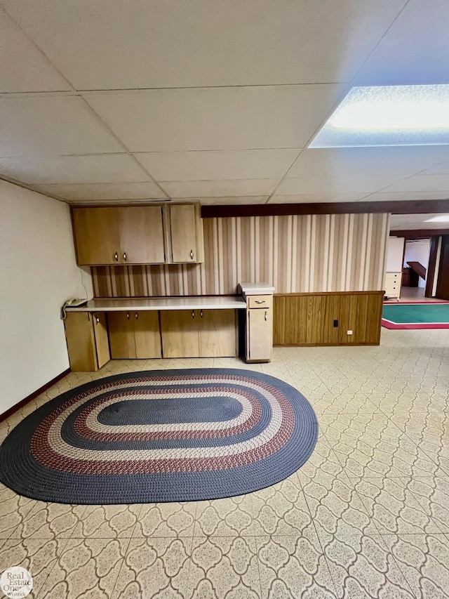 interior space with wooden walls and a drop ceiling