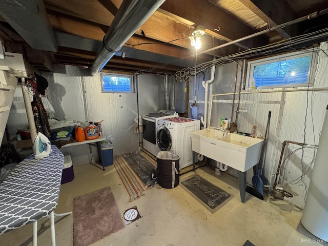 basement featuring electric panel, sink, and washer and dryer