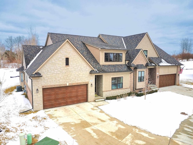 view of front of home featuring a garage and central AC