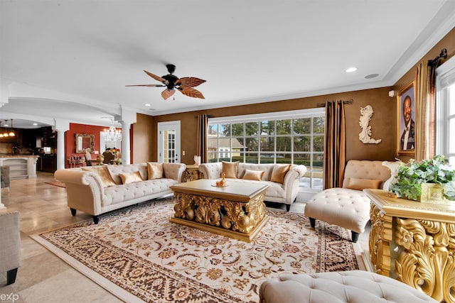 living room with ornate columns, crown molding, ceiling fan with notable chandelier, and light tile patterned floors