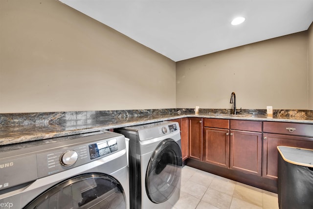 laundry room with cabinets, washing machine and clothes dryer, sink, and light tile patterned floors