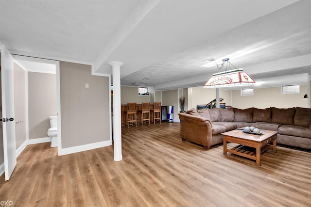 living room with bar and light wood-type flooring