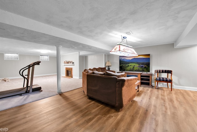 living room with a fireplace, wood-type flooring, and a textured ceiling