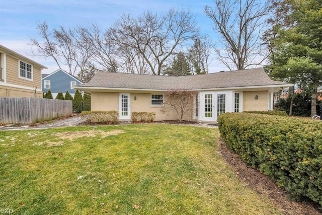 back of property with a lawn and french doors