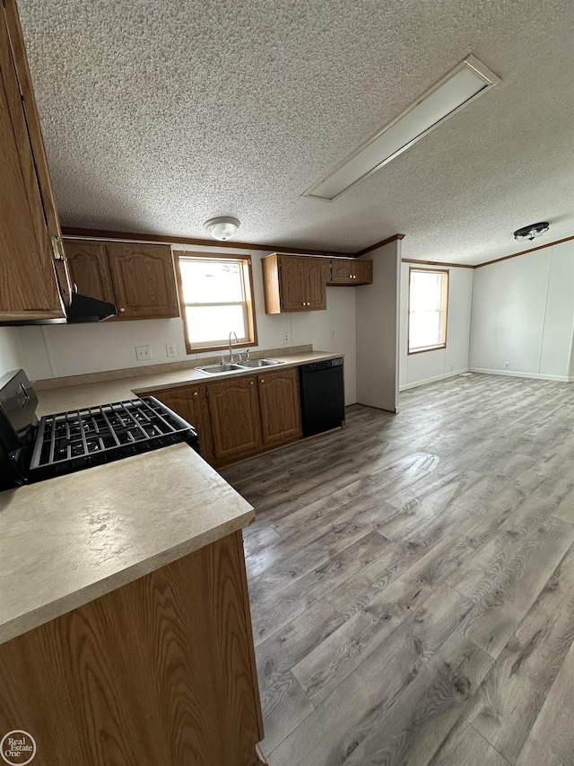 kitchen with sink, light wood-type flooring, black appliances, crown molding, and a textured ceiling