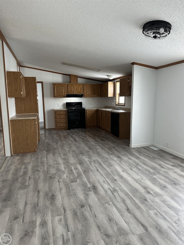 kitchen featuring sink, crown molding, black appliances, vaulted ceiling, and light wood-type flooring