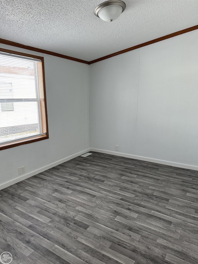 unfurnished room with crown molding, dark wood-type flooring, and a textured ceiling