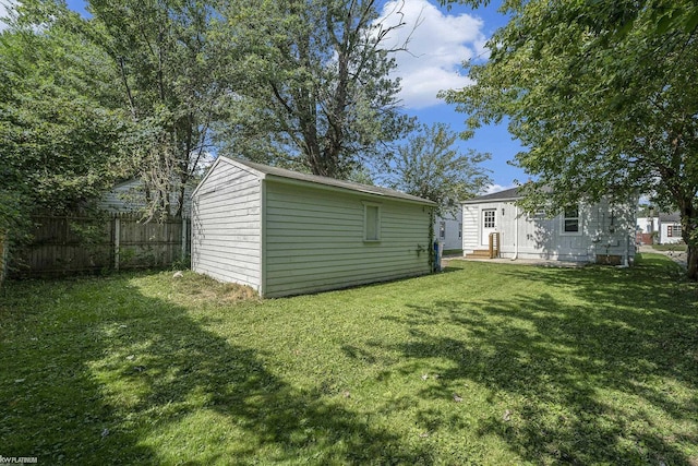 rear view of house featuring an outbuilding and a yard