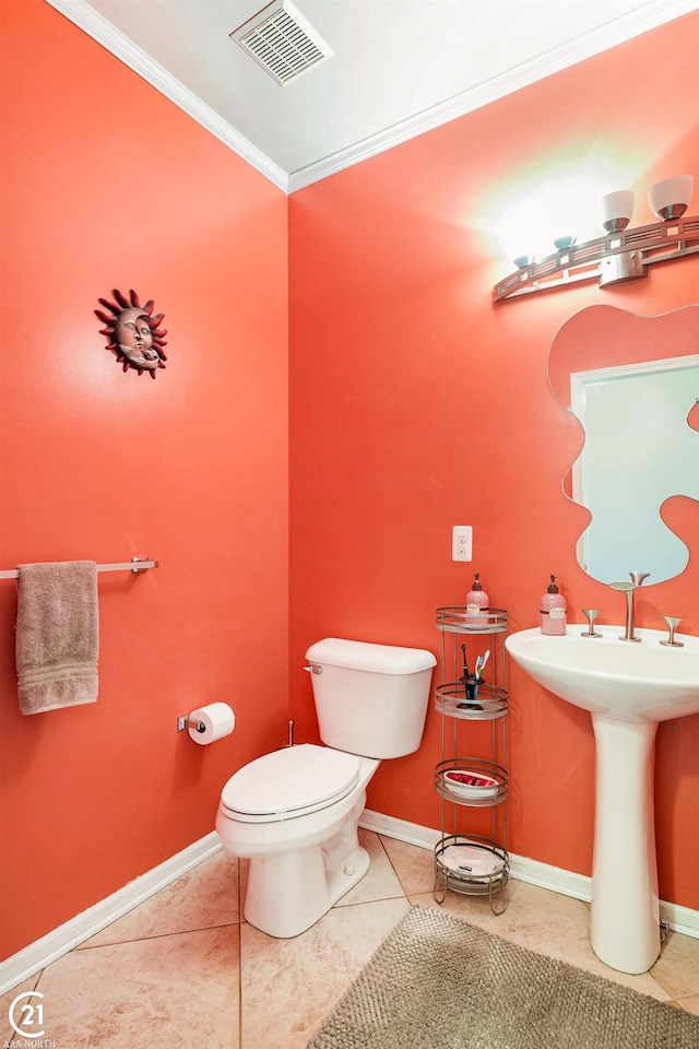 bathroom with tile patterned flooring, crown molding, and toilet