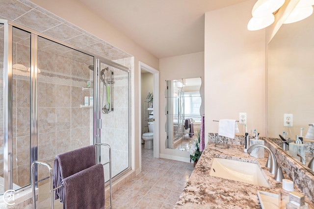 bathroom featuring vanity, a shower with shower door, tile patterned floors, and toilet