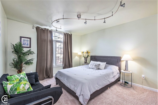 carpeted bedroom featuring track lighting