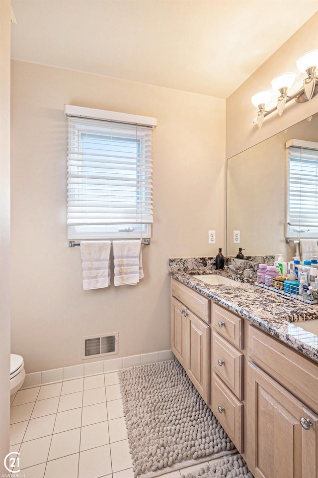 bathroom featuring vanity, tile patterned floors, and toilet