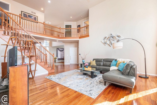 living room with light hardwood / wood-style flooring and a high ceiling