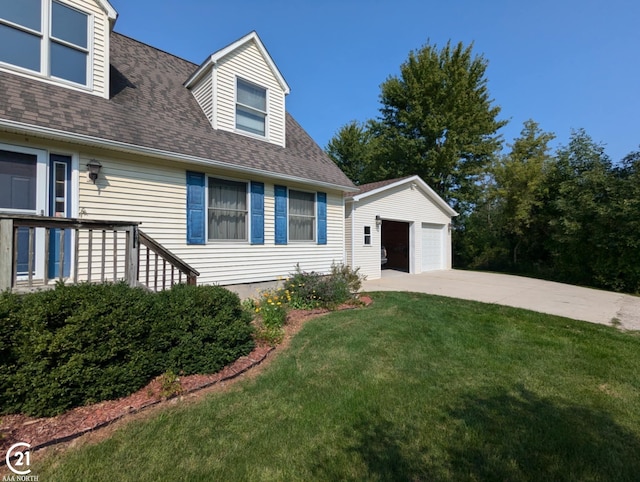 view of front of house featuring a garage, an outdoor structure, and a front yard