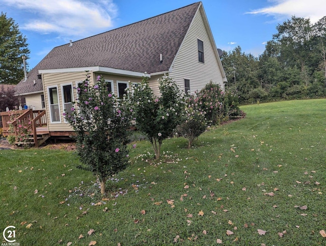 rear view of property with a wooden deck and a yard