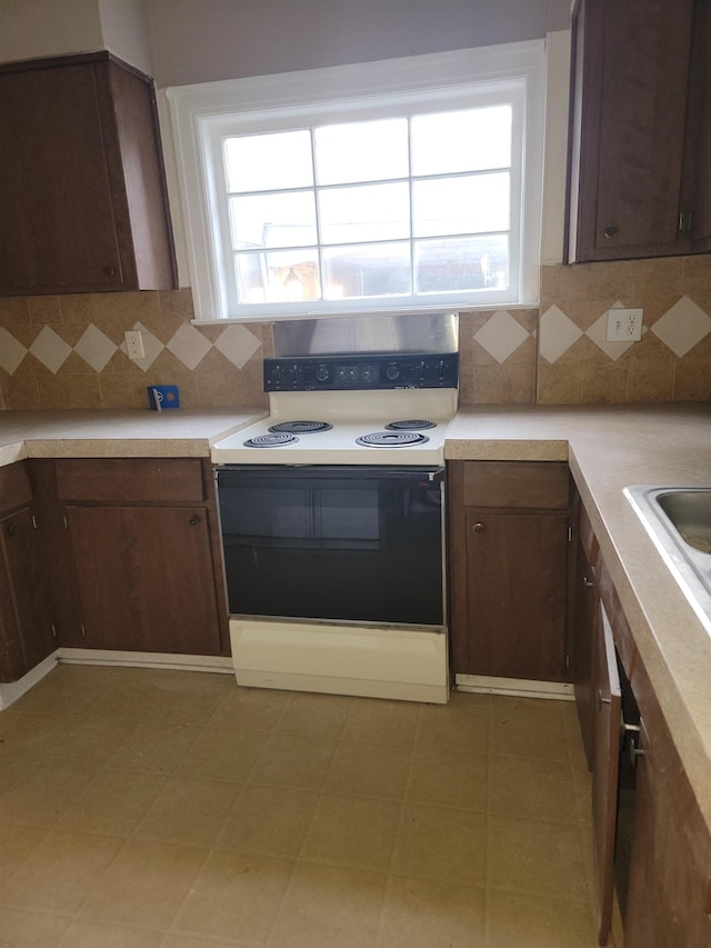 kitchen featuring range with electric stovetop, dark brown cabinets, and backsplash