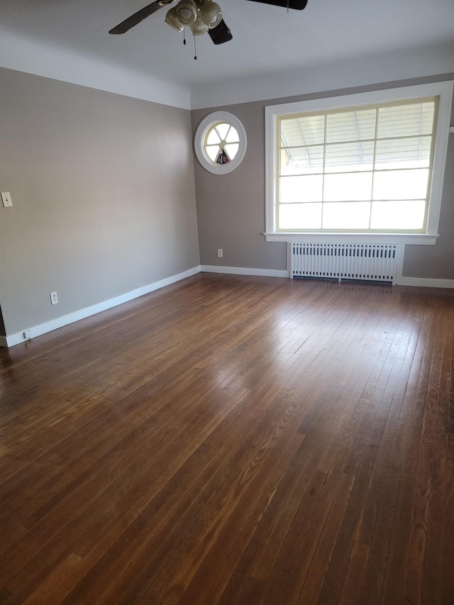 spare room with ceiling fan, dark hardwood / wood-style flooring, and radiator